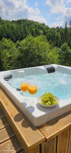 a hot tub with two drinks and a plate of grapes at Widokownia Brenna in Brenna