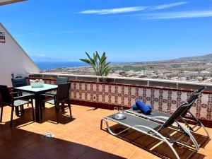 een patio met een tafel en stoelen op een balkon bij Costa Adeje Sunset Apartment in Adeje