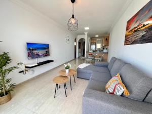 een woonkamer met een bank en een tafel bij Costa Adeje Sunset Apartment in Adeje