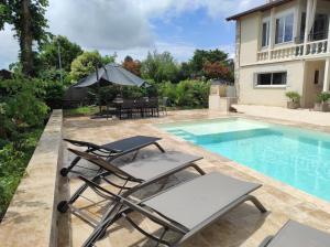 a patio with chairs and a swimming pool at Gîte Ladeveze in Nérac