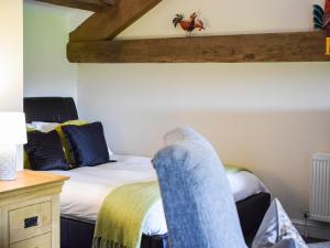 a bedroom with a bed and a desk with a bedskirts at The Studio At Malt Kiln Cottage in Grizebeck
