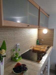 eine Küche mit einem Waschbecken und einer Schale Obst in der Unterkunft Apartman Becici in Budva