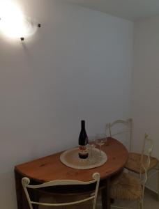 einen Tisch mit einer Flasche Wein und zwei Gläsern darauf in der Unterkunft Apartman Becici in Budva