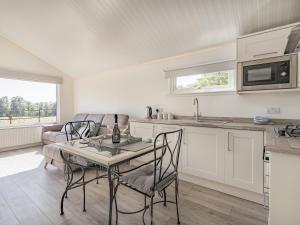 uma cozinha e sala de estar com mesa e cadeiras em The Tranquil Orchard - Nuthatch-uk32791 em Mouswald
