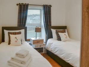 two beds in a room with a mirror at The Alnwick Townhouse in Alnwick