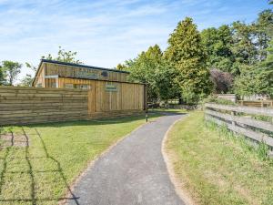 una casa de madera con una valla y una carretera en The Tranquil Orchard - Nuthatch-uk32791 en Mouswald