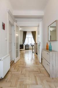 ブダペストにあるModern spacious flat in Budaのウッドフロアと白い壁のリビングルーム