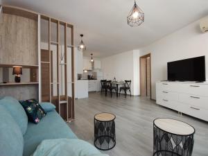 een woonkamer met een blauwe bank en een tv bij Apartament Sea Fort Club Grand Resort Fort Noks Sveti Vlas-Bastet BS in Elenite