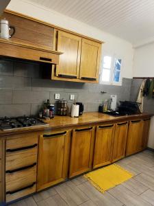 - une cuisine avec des placards en bois et une cuisinière dans l'établissement Ti kaz cannelle, à Saint-Louis