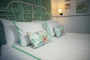 Una cama blanca con dos almohadas encima. en Vinnus Guesthouse en Ericeira