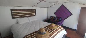 Un dormitorio con una cama con dos sombreros. en CHUYPAS DEL TITICACA, en Puno