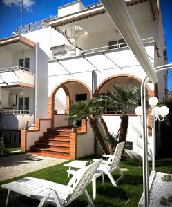 a pair of white chairs in front of a house at Al civico 28 in Santa Marinella