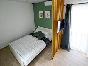 a small bedroom with a bed and a mirror at Modern studio overlooking downtown in Makarska