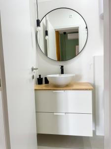 a bathroom with a white sink and a mirror at Modern studio overlooking downtown in Makarska