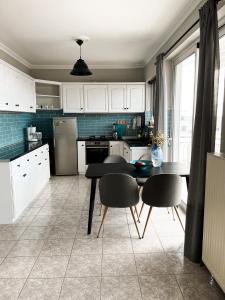 a kitchen with white cabinets and a table and chairs at Porto Pireo Penthouse Sea View in Piraeus