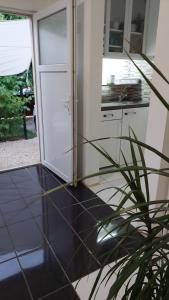 uma cozinha com piso em azulejo preto e uma porta em Oázis Apartman, Gárdony, Velencei-tó em Gárdony
