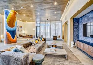 uma grande sala de estar com um sofá e uma televisão em Modern Downtown Condo - Rooftop pool - Top Amenities em Austin