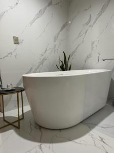 a white bath tub in a bathroom with marble walls at Hotel Garcia Peral in Huajuapan de León