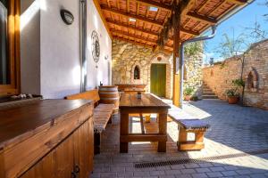 un patio al aire libre con mesa de madera y bancos en Penzion U TŘÍ RŮŽÍ, en Vrbice