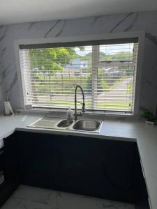 uma cozinha com um lavatório e uma janela em Erskine Apartment em Erskine