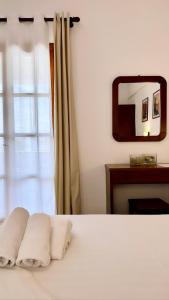a bedroom with a bed with two pillows and a mirror at Dina Naxos Studios in Agios Prokopios