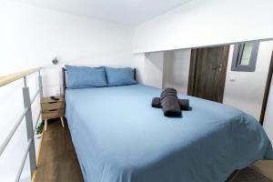 um quarto com uma cama grande e lençóis azuis em Dimosthenis_Loft1 em Atenas