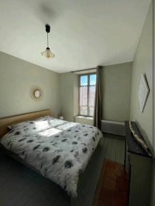 ein Schlafzimmer mit einem großen Bett und einem Fenster in der Unterkunft Appartement Le feron in Vic-sur-Cère
