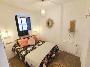 a bedroom with a bed and a window at La Martela de Fuentes Casa de diseño rural in Fuentes de León