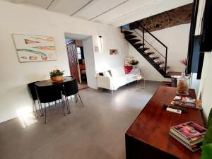 a living room with a staircase and a table and chairs at La Martela de Fuentes Casa de diseño rural in Fuentes de León