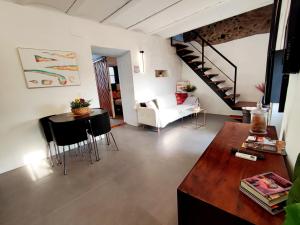 uma sala de estar com uma escada e uma mesa e cadeiras em La Martela de Fuentes Casa de diseño rural em Fuentes de León
