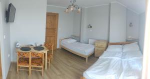 a bedroom with a bed and a desk and a table at Willa Arkadia in Władysławowo