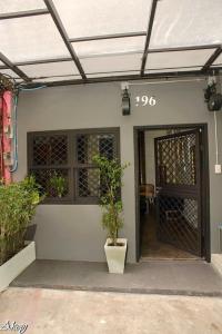 une porte d'entrée d'une maison avec une usine dans l'établissement Inner Old Town 196 Chic Guesthouse, à Bangkok