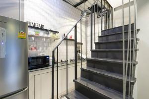 a kitchen with a staircase leading up to a microwave at Inner Old Town 196 Chic Guesthouse in Bangkok