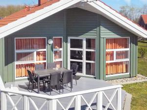 ein Haus mit einem Tisch und Stühlen auf einer Terrasse in der Unterkunft 6 person holiday home in Otterndorf in Otterndorf