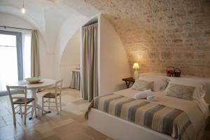 - une chambre avec un lit et une table dans l'établissement Masseria Parco della Grava, à Pezze di Greco
