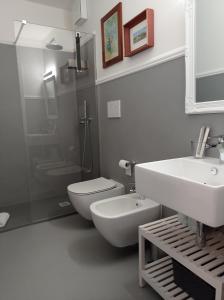 La salle de bains blanche est pourvue de toilettes et d'un lavabo. dans l'établissement B&B S. Trinità 18 Suites & Rooms, à Trente