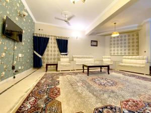 een woonkamer met een tafel en een tapijt bij Dream Inn Guest House in Islamabad