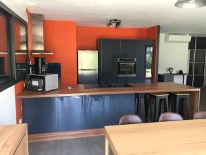 a kitchen with wooden counter tops and an orange wall at Le chêne enchanté à 10' du Puy du Fou in Saint-Laurent-sur-Sèvre +15 photos