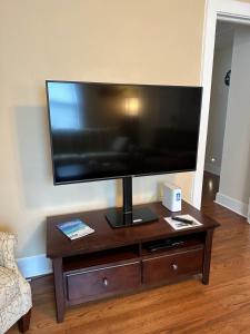 a flat screen tv sitting on top of a wooden table at Calypso Pensacola in East Hill Neighborhood ! in Pensacola