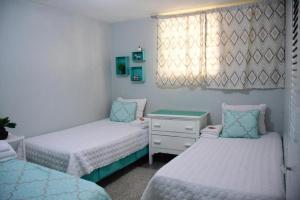 een slaapkamer met 2 bedden, een dressoir en een raam bij Apartamento entero en Samaná Los tios in Santa Bárbara de Samaná