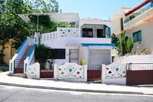 een wit huis met een hek ervoor bij Apartamento entero en Samaná Los tios in Santa Bárbara de Samaná