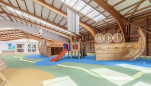 uma área de recreação infantil com escorrega e um parque infantil em Confort et Convivialité Cottage 6 Personnes Terrasse Privé em Branville