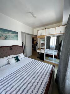 a bedroom with a large bed with a striped blanket at 1 BR Centrio Tower 926 in Cagayan de Oro