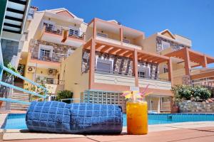 a blue couch and a drink in front of a building at HOTEL VICKY II in Plomari