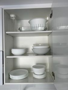 een witte kast gevuld met witte kommen en borden bij AM DEL SOL in Fuengirola