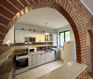 a kitchen with a brick wall and an archway at Alex Guesthouse in Kotor