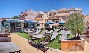 a patio with tables and chairs in front of a building at HOTEL VICKY II in Plomari