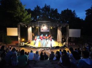 una multitud de personas viendo una banda en un escenario en Vue panoramique mer et collines, en Grimaud