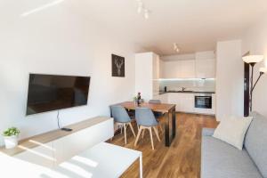 a kitchen and living room with a table and a couch at Beauty Apartment Zablocie 35 Wifi Balcony in Krakow