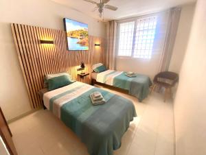 een hotelkamer met 2 bedden en een televisie bij Vivir La Vida in Cala Ratjada